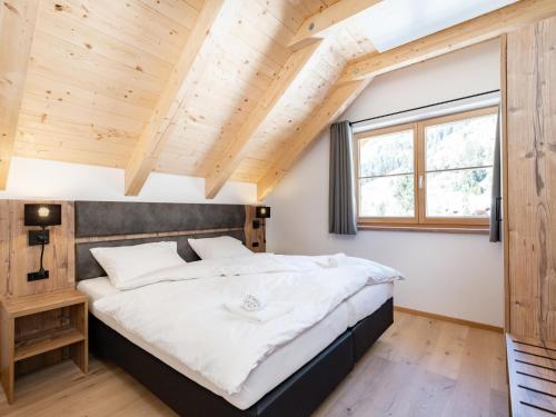 een slaapkamer met een groot bed en houten plafonds bij Steier Hütte S in Donnersbachwald