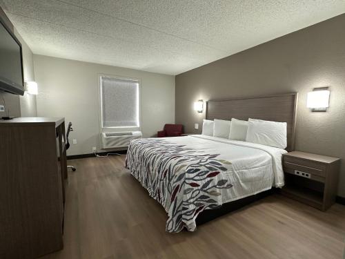 a hotel room with a bed and a television at Red Roof Inn Richmond, VA - W Broad St in Richmond