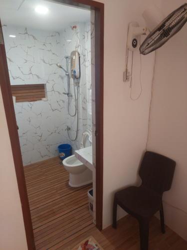uma casa de banho com um WC, uma cadeira e um chuveiro em Frozen 2 em Puerto Princesa
