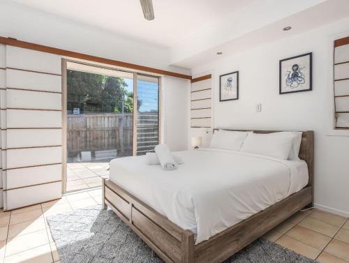 a bedroom with a large bed and a large window at Hastings Cove Holiday Apartments in Hastings Point