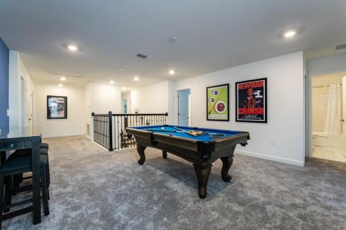 a room with a pool table in a house at Amazing 8br w pool theater game room by Disney in Kissimmee