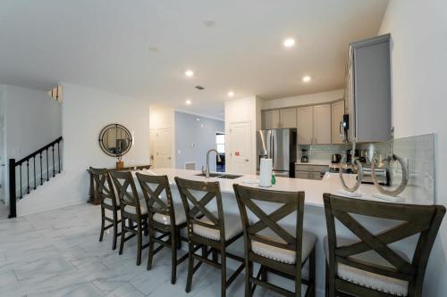 a kitchen with a bar with chairs around it at Amazing 8br w pool theater game room by Disney in Kissimmee