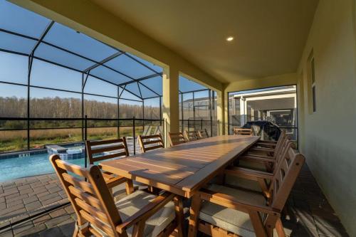 a dining room with a wooden table and chairs at Amazing 8br w pool theater game room by Disney in Kissimmee