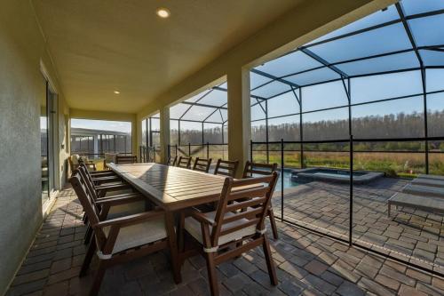 a conservatory with a table and chairs on a patio at Amazing 8br w pool theater game room by Disney in Kissimmee