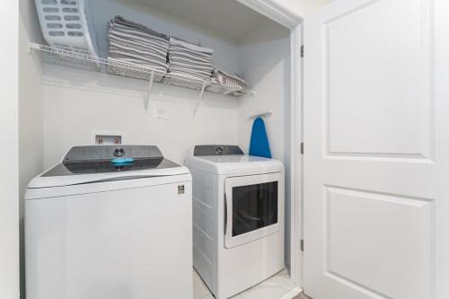 a washer and dryer in a white laundry room at Amazing 8br w pool theater game room by Disney in Kissimmee