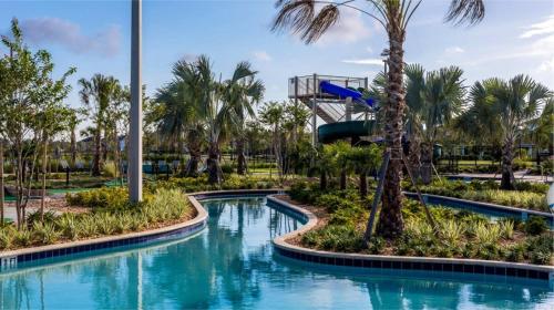 a water slide in a park with palm trees at Amazing 8br w pool theater game room by Disney in Kissimmee