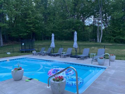 una piscina con sedie e ombrelloni in un cortile di Top of the Stretch Oasis a Saratoga Springs