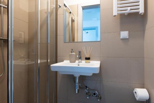 een badkamer met een wastafel en een douche bij Monciak Comfort - Hipodrom in Sopot