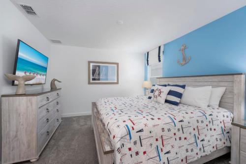 a bedroom with a king sized bed and a dresser at Amazing 8br w pool theater game room by Disney in Kissimmee