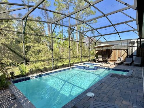 an indoor swimming pool with a glass roof at Amazing 6br w pvt pool game room near Disney in Kissimmee