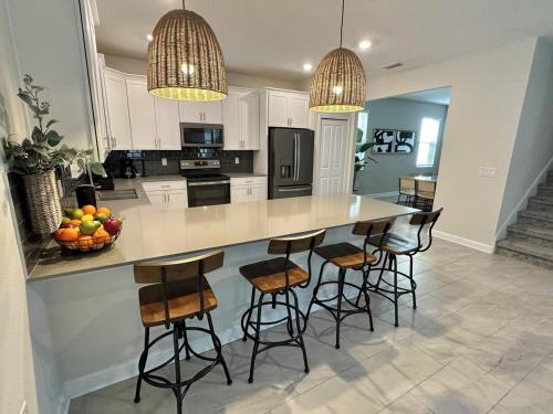 a kitchen with a large island with bar stools at Amazing 6br w pvt pool game room near Disney in Kissimmee