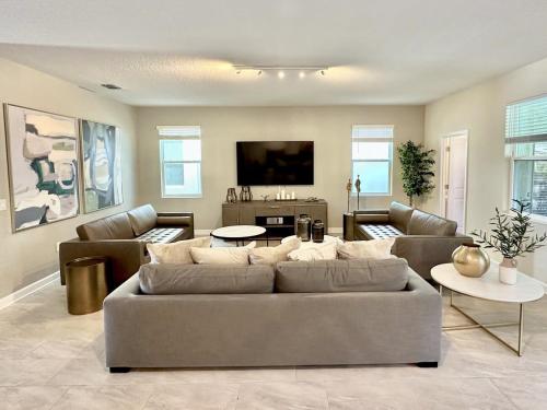 a living room with a couch and a tv at Amazing 6br w pvt pool game room near Disney in Kissimmee