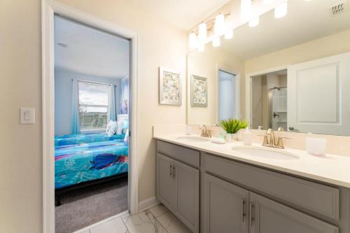 ein Badezimmer mit zwei Waschbecken und einem großen Spiegel in der Unterkunft Vibrant 6BR w Private Pool Grill by Disney in Davenport