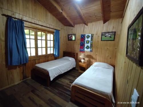 een slaapkamer met 2 bedden in een houten hut bij Wild Wetlands Lodge in Ituzaingó