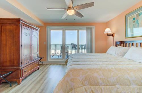 a bedroom with a bed and a ceiling fan at Carolina Surf - 3BR Condo with Stunning Ocean Views in Carolina Beach