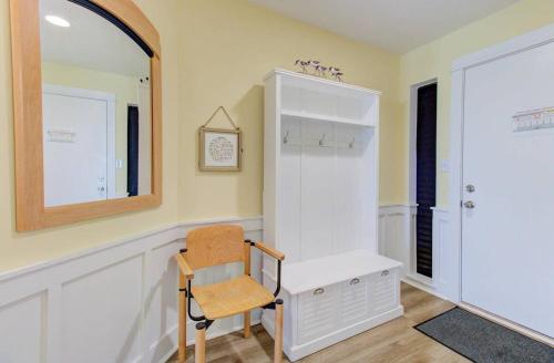 a chair in a room with a desk and a mirror at Carolina Surf - 3BR Condo with Stunning Ocean Views in Carolina Beach
