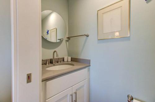 a bathroom with a sink and a mirror at Carolina Surf - 3BR Condo with Stunning Ocean Views in Carolina Beach