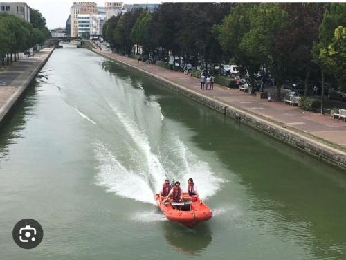 un groupe de personnes sur un bateau dans une rivière dans l'établissement The Unforgetable at Canal de l'Ourcq, à Paris