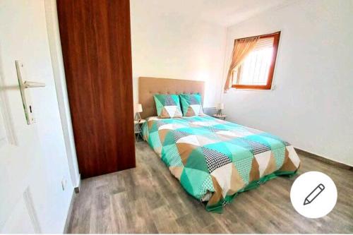1 dormitorio con 1 cama con cruz en el suelo en La Courtoise 2 Moissy-Cramayel, en Moissy-Cramayel