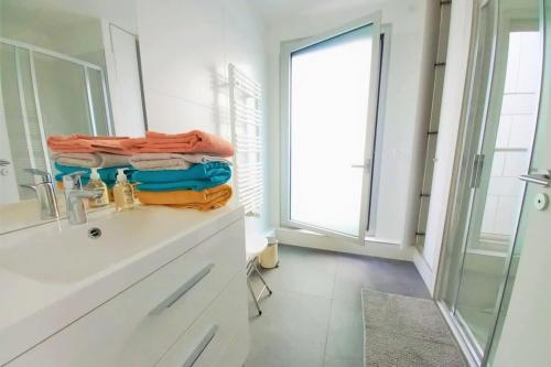 La salle de bains est pourvue d'un lavabo et d'un comptoir avec des serviettes. dans l'établissement Modern and Smart - Paris 13, à Paris