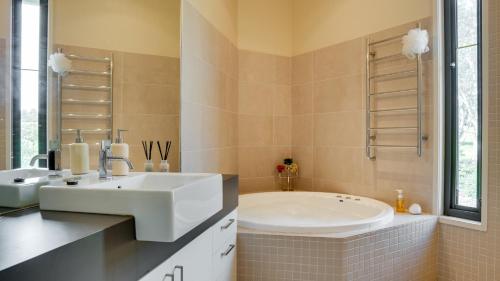 Wonga Park的住宿－Yarra Valley Serenity House in Golf Course Resort，浴室配有白色水槽和浴缸。