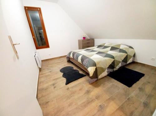 a bedroom with a bed and a wooden floor at La Chaleureuse crepes et raclettes apres travail in Moissy-Cramayel