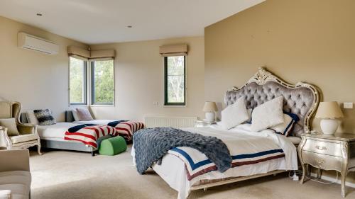 Wonga Park的住宿－Yarra Valley Serenity House in Golf Course Resort，一间带两张床和一张沙发的大卧室