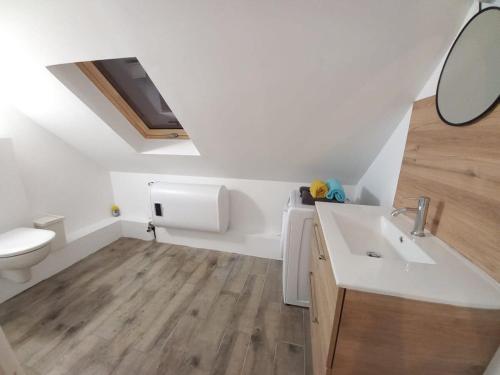 uma casa de banho branca com um lavatório e um WC em La Chaleureuse crepes et raclettes apres travail em Moissy-Cramayel