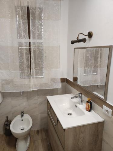 bagno con lavandino, servizi igienici e specchio di Casa Giannina a Palermo