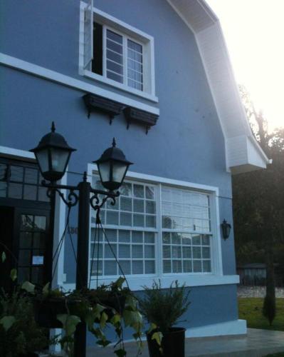 uma casa azul com uma janela e uma luz de rua em Hotel Jardim Bulevard em Ituporanga