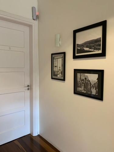 a white door with three pictures on a wall at Hotel Jardim Bulevard in Ituporanga