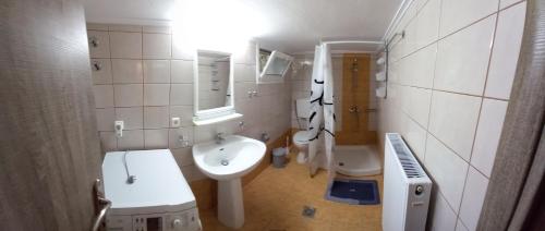 a white bathroom with a sink and a toilet at ARMONIA HOUSE in Kallithéa