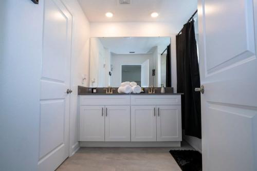 a bathroom with a white sink and a mirror at Gorgeous 4 Bedroom w Screened Pool Close to Disney 2653 in Kissimmee