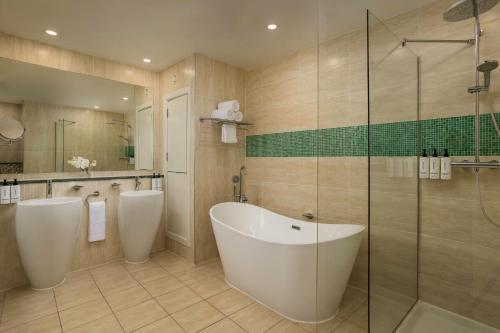 a bathroom with two sinks and a tub and a shower at Crowne Plaza Dublin Blanchardstown by IHG in Blanchardstown