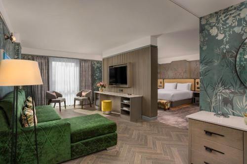 a hotel room with a bed and a couch at Crowne Plaza Dublin Blanchardstown by IHG in Blanchardstown