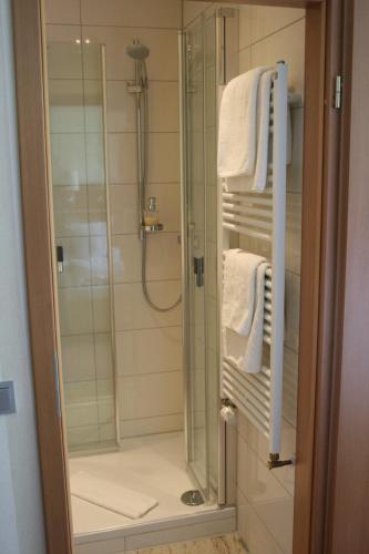 eine Dusche im Bad mit weißen Handtüchern in der Unterkunft Hotel-Restaurant Fasanerie in Marburg an der Lahn