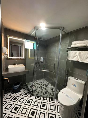 a bathroom with a shower and a toilet and a sink at Nhật Tân Hotel in Hanoi