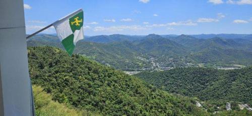 un drapeau battant au sommet d'une colline avec des montagnes dans l'établissement Hacienda JM's, 