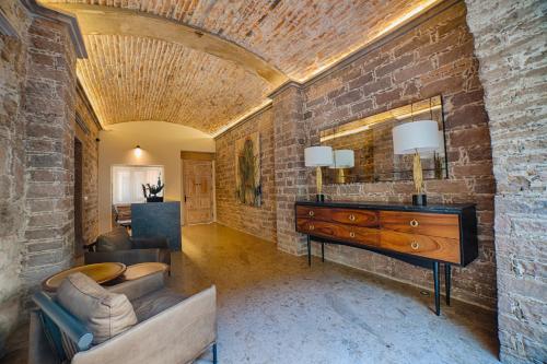 a living room with a brick wall and a dresser at HOTEL CASA ARANZAZU SAN LUIS POTOSI in San Luis Potosí