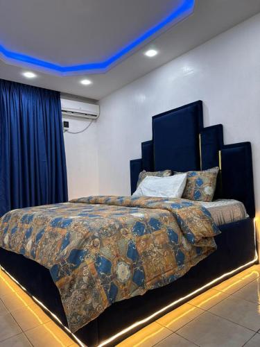 um quarto com uma cama grande e um tecto azul em Frontline em Lagos
