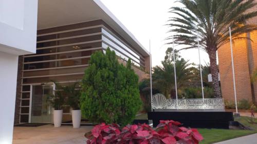 a building with pink flowers in front of it at Hotel Margarita Real apartarmento 1202 in Porlamar