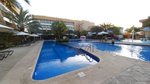 a large blue swimming pool in a resort at Hotel Margarita Real apartarmento 1202 in Porlamar