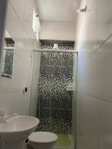a bathroom with a shower with a toilet and a sink at Pousada Familia Aparecida in Aparecida