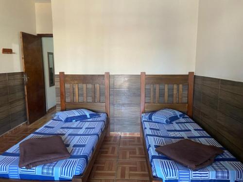 two twin beds in a room withthritisthritisthritisthritisbestosbestosbestosbestosbestos at Pousada Familia Aparecida in Aparecida