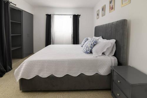een slaapkamer met een groot bed met een grijs hoofdeinde bij Casa Mango- Mountain & Sea Panoramic view - 3Bedrooms in San Felipe de Puerto Plata