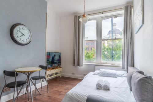 ロンドンにある2 Bedroom apartment in Central Londonのベッドルーム1室(ベッド1台、壁掛け時計付)