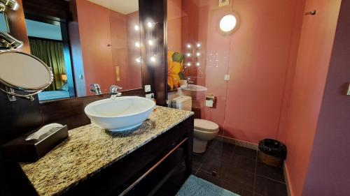La salle de bains est pourvue d'un lavabo et de toilettes. dans l'établissement TAHITI - Condo Lafayette Beach, à Arue