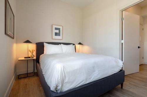 een slaapkamer met een groot bed met witte lakens bij Conway B203 by AvantStay Private Balcony 5mins to Broadway in Nashville