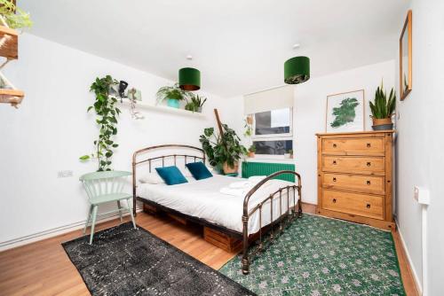 een slaapkamer met een bed en een dressoir bij Cozy 1-Bedroom Oasis with Balcony in London's Heart in Londen
