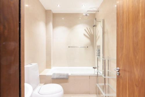a bathroom with a shower and a toilet and a tub at Modern and comfortable air-conditioned 2BR flat in London